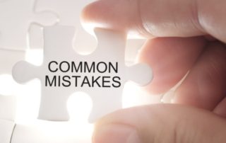 COMMON MISTAKES word on jigsaw puzzle. Businessman hands holding white puzzle business concept.
